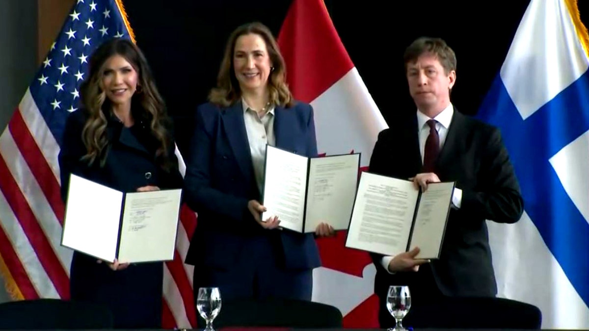 Kristi Noem, Kirsten Hillman and Sakari Puisto hold signed letters of intent