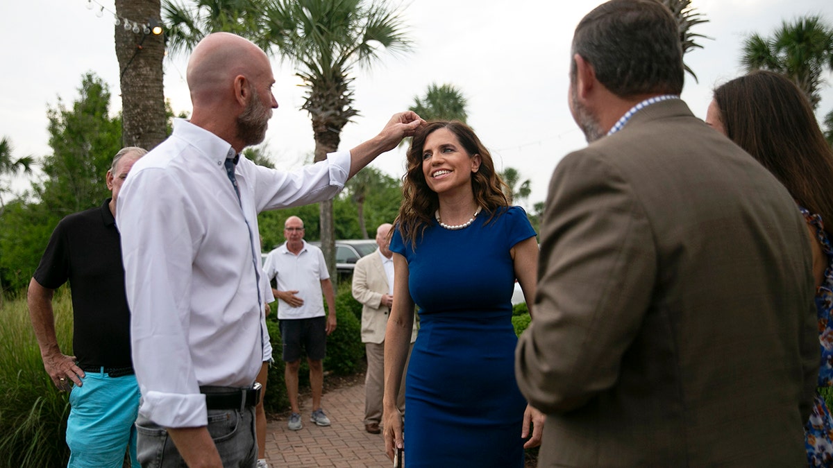 Patrick Bryant adjusts hair of Nancy Mace