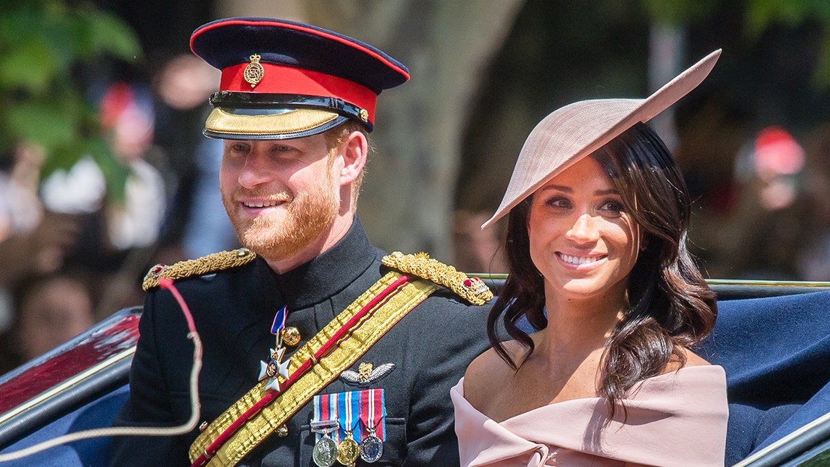 Meghan Markle and Prince Harry in formal wear in a royal carriage.