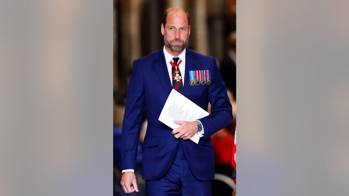 Prince William wearing a blue suit with medals.