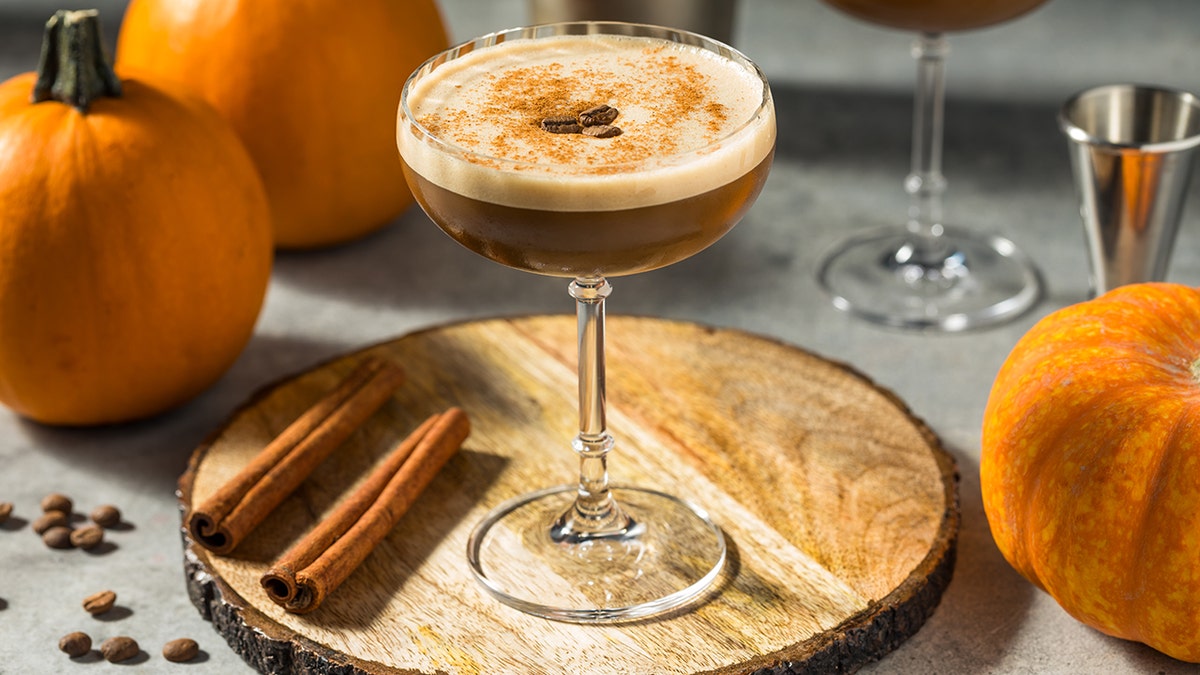 Pumpkin spice espresso martini mocktail garnished with cinnamon and coffee beans.