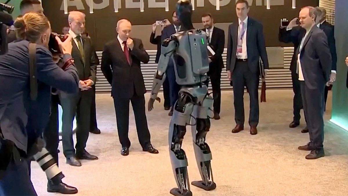 Putin surrounded by bodyguards arsenic  the robot dances. 