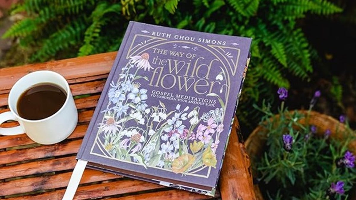 A cup of coffee is placed next to Ruthe Chou Simons' book.