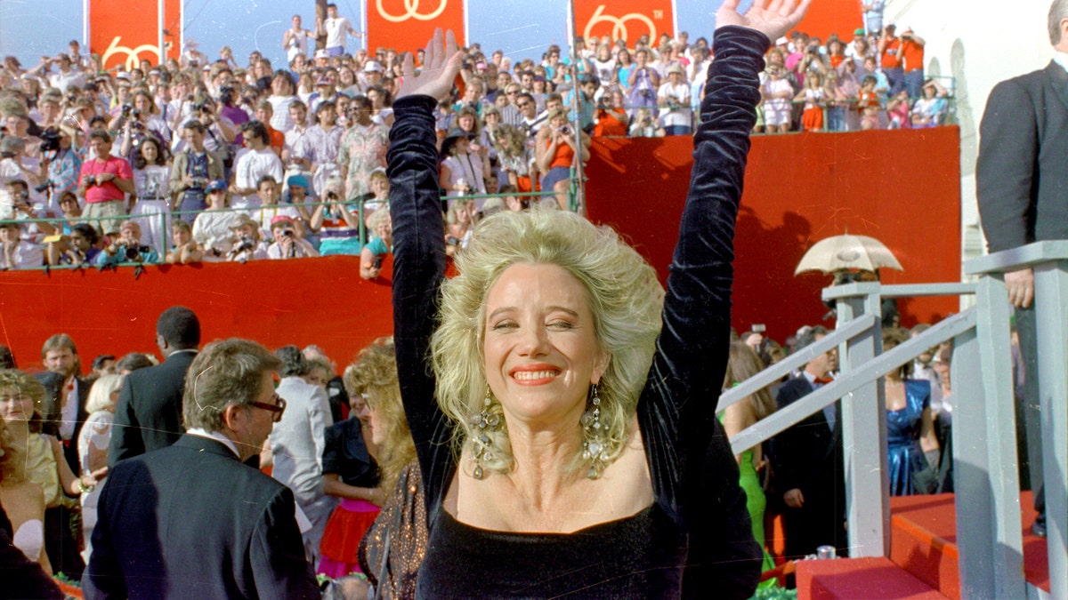 Sally Kirkland raises her arms at the Oscar awards ceremony