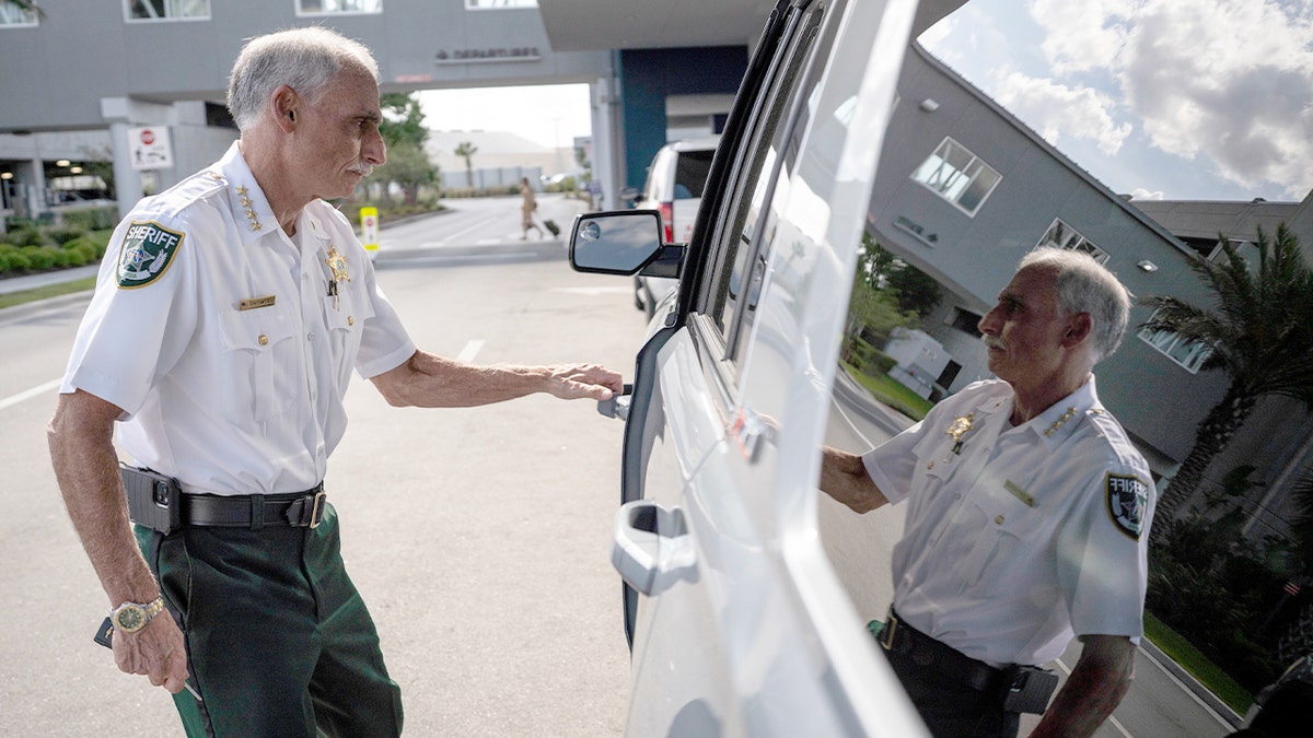 Volusia County Sheriff Mike Chitwood walks outside Orlando Sanford International Airport.