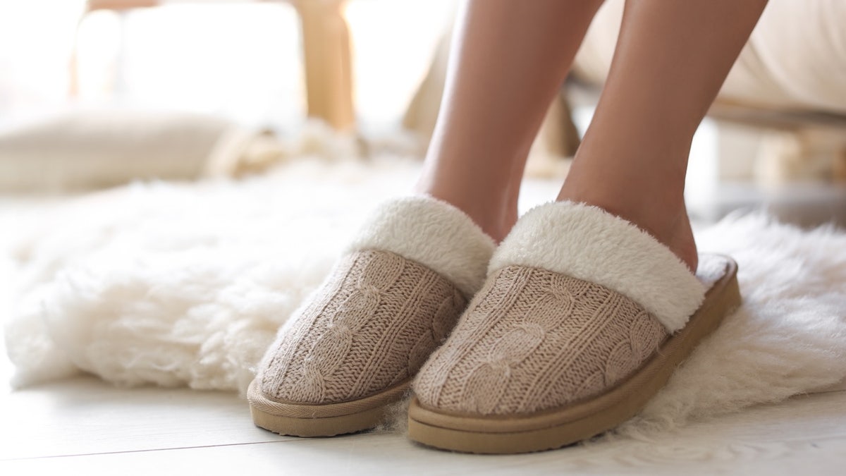 Woman wearing soft comfortable slippers at home, closeup