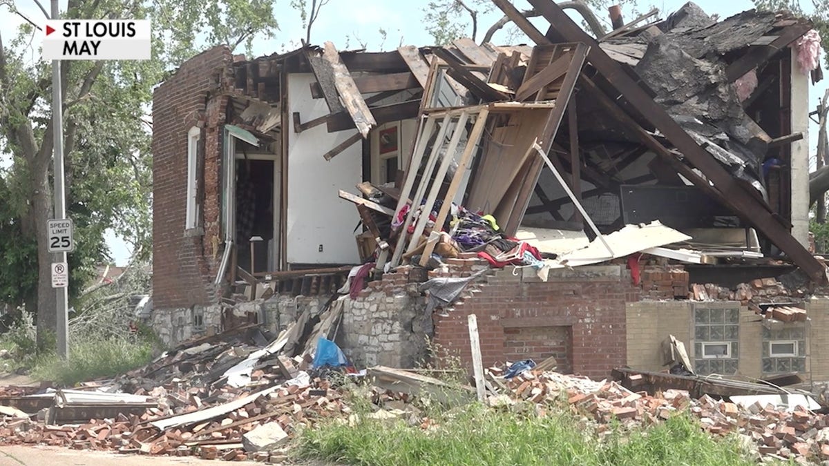 A heavily damaged brick home in St. Louis with its walls collapsed and debris scattered across the ground after the May tornado.