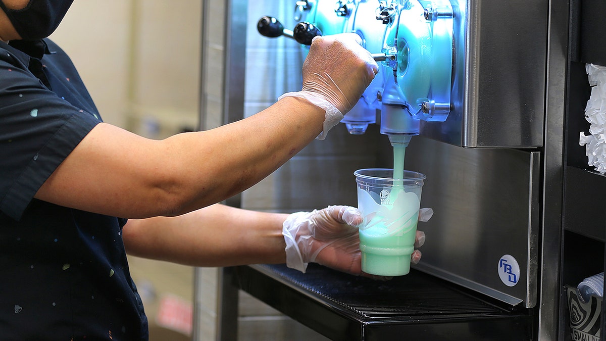 An employee serves dew dew dew baja adrozer drinks from a frozen drink machine at the Taco Bell New Cantina in Brookline, MA