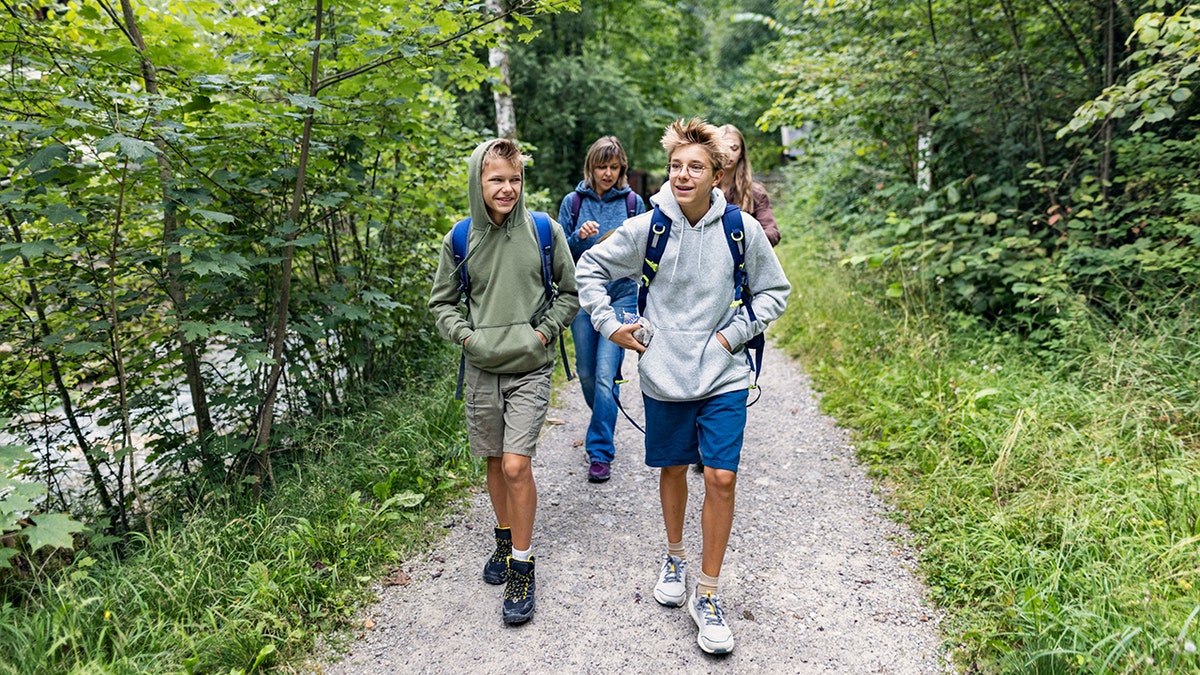 two teen boys lead the pack while on a hike