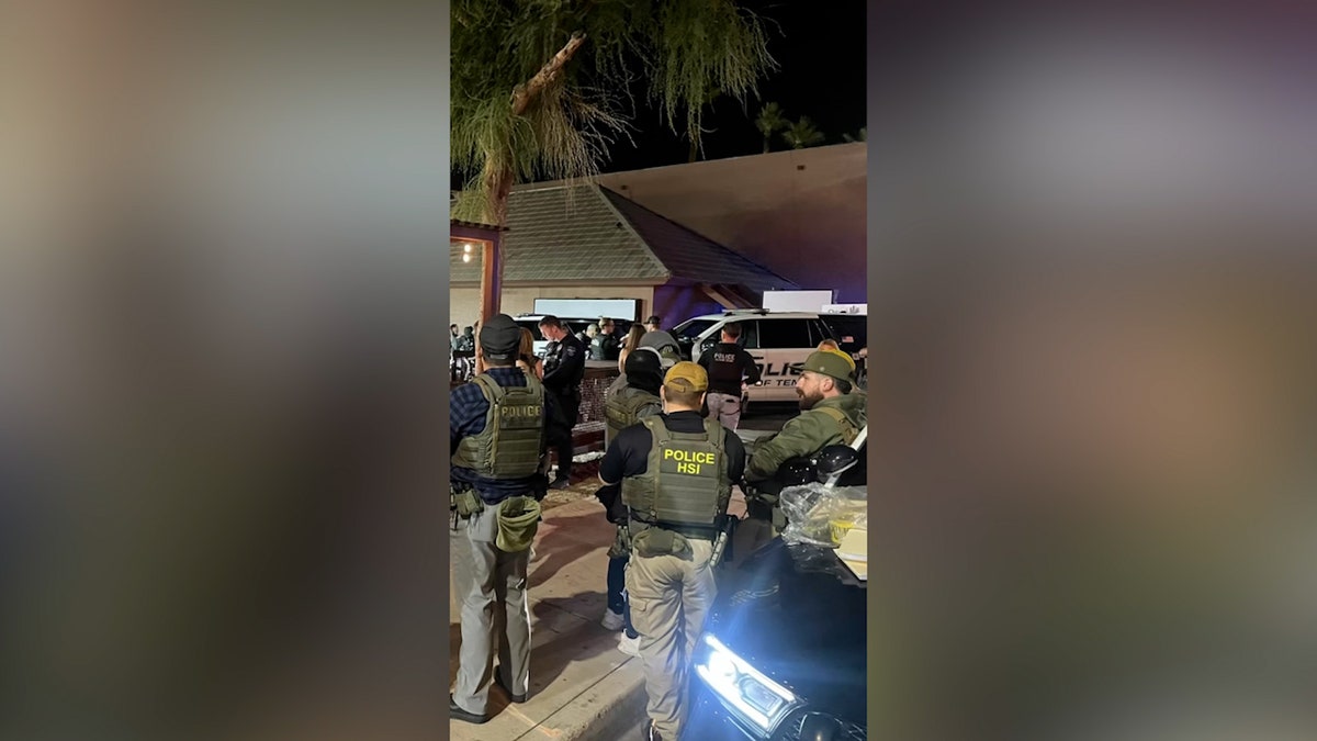 agents including HSI officers gather outside bar