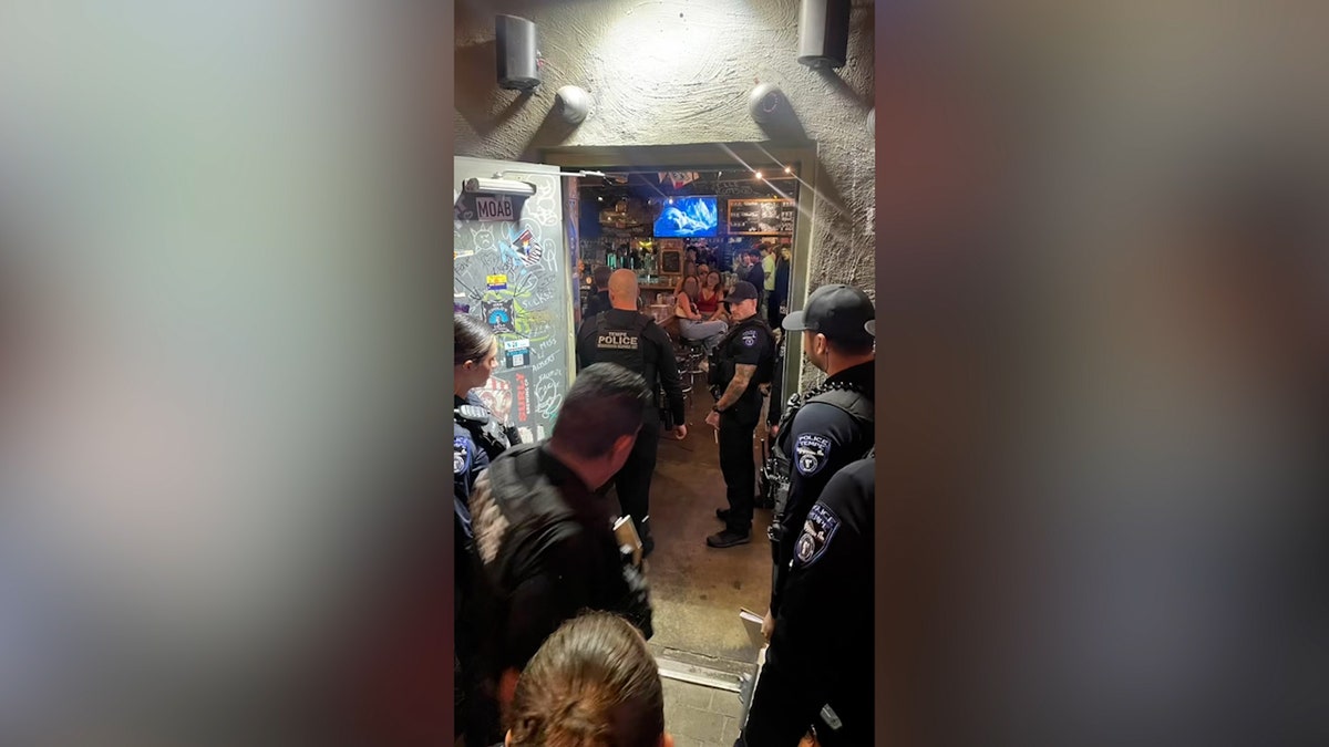 police officers enter bar with customers