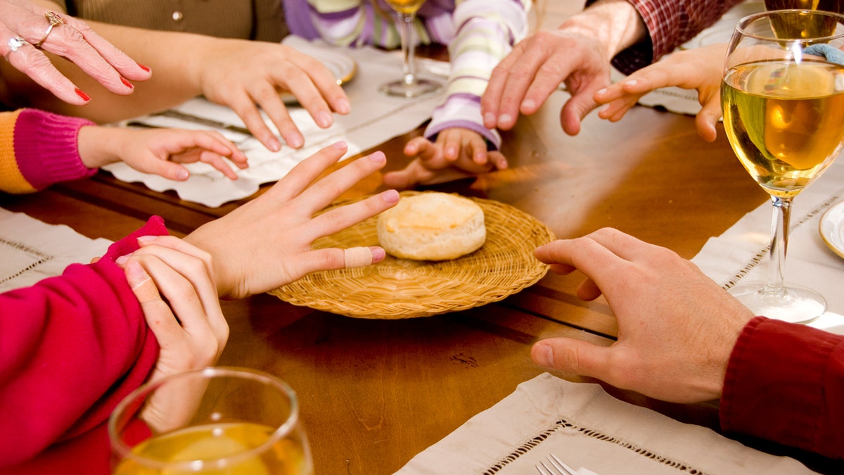 familie aan eettafel vechtend om koekjeshanden die uitreiken om te grijpen