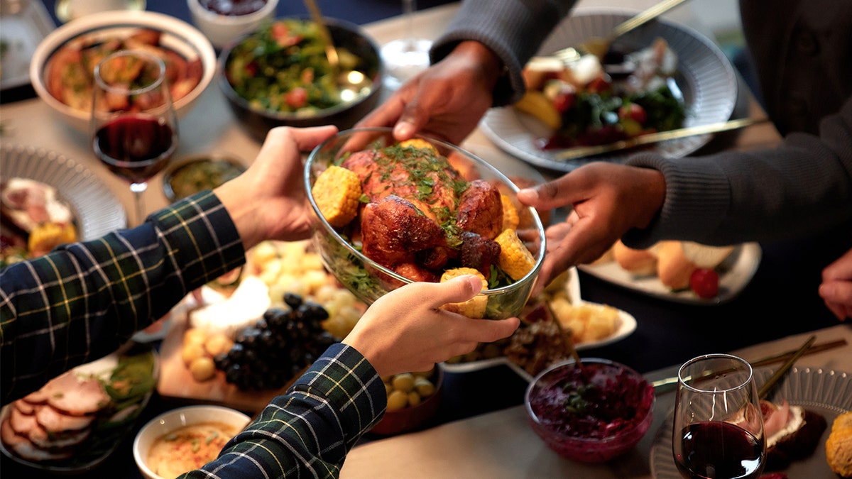 People handing over Thanksgiving turkey at table