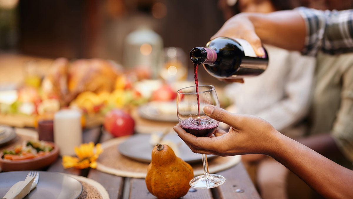 Woman pouring wine at Thanksgiving table
