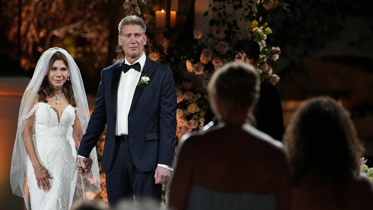 Gerry Turner and Theresa Nist in their wedding attire looking emotionally at Turner's daughters.