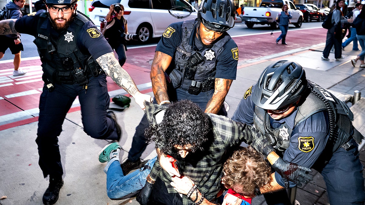 Police separating two men on sidewalk