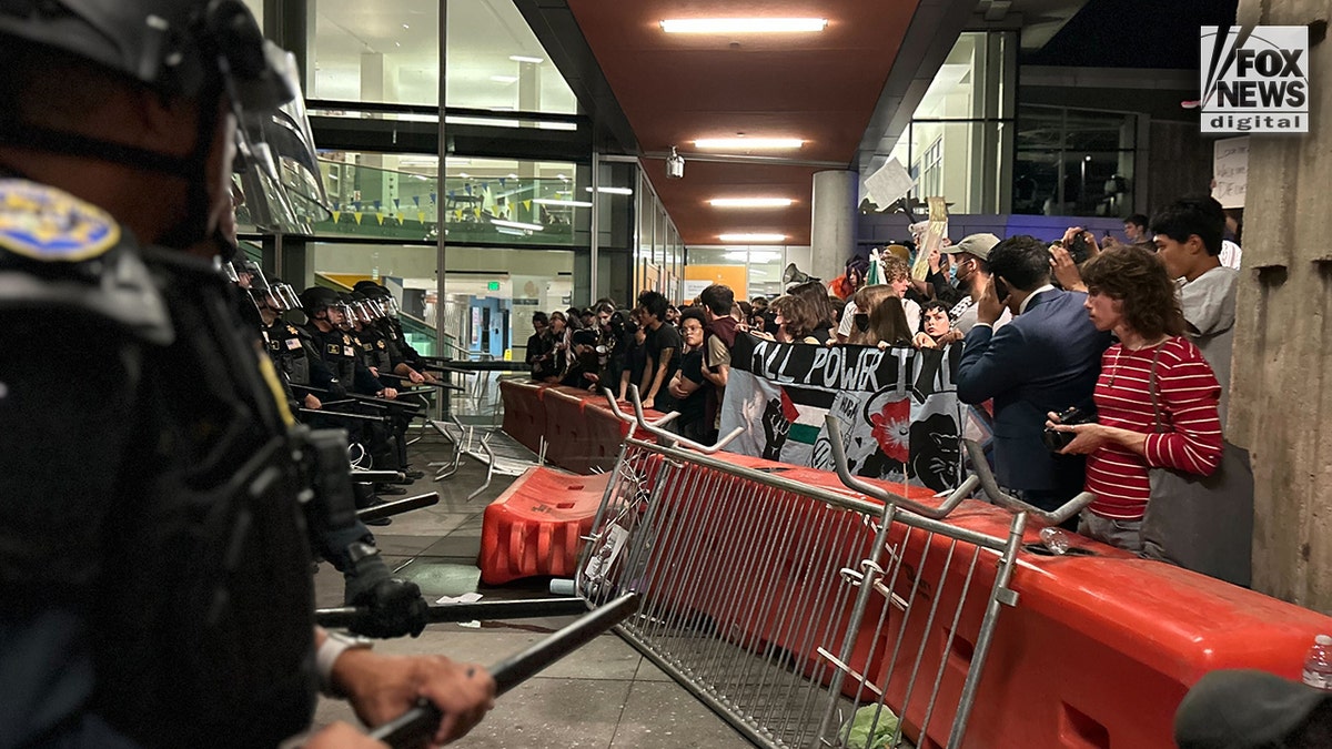 UC-Berkeley protesters next to police.