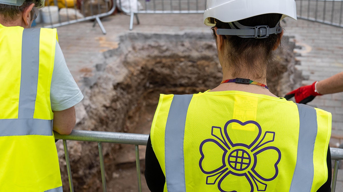 Archaeologist looking astatine excavation pit.