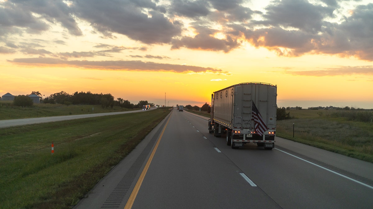 A semi-truck drives on a highway