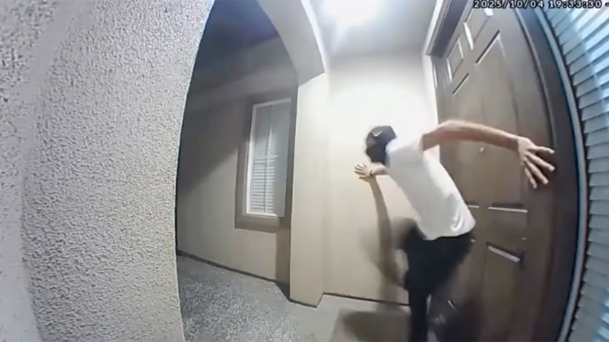 A masked individual kicks the front door of a California home
