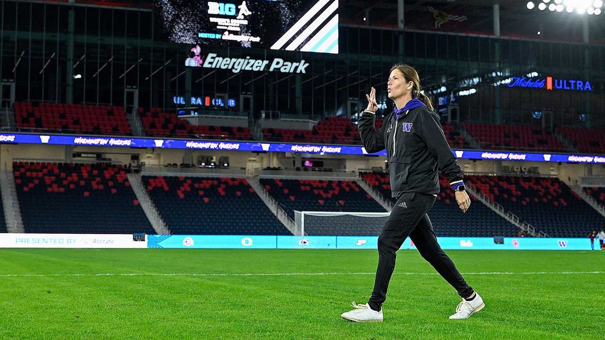 Coach Nicole van Dyke walks on field