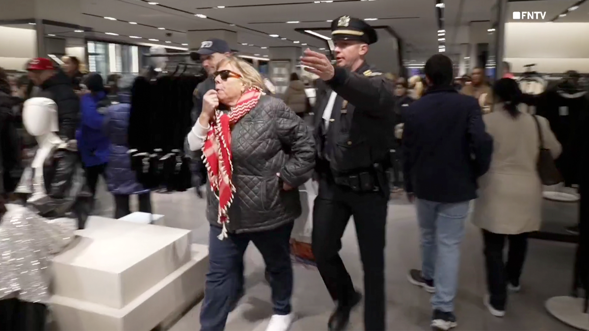 Protester blows a whistle inside New York City ZARA store on Black Friday.