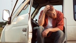 Farmer struggling with the economy looks sad from his truck