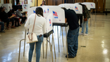 People are seen in voting booths in Maryland on Election Day.