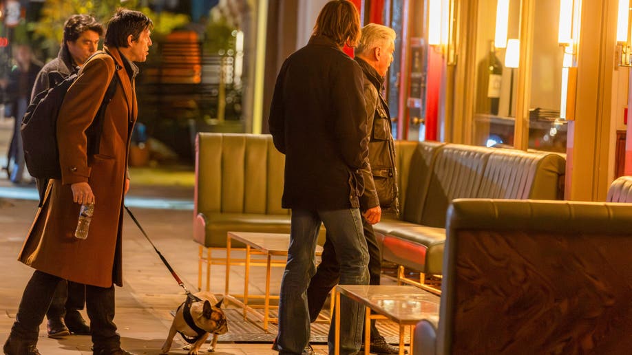 Pierce Brosnan walks into Dorian restaurant in London with his sons Christopher and Dylan Brosnan, joined by a small dog on a leash.
