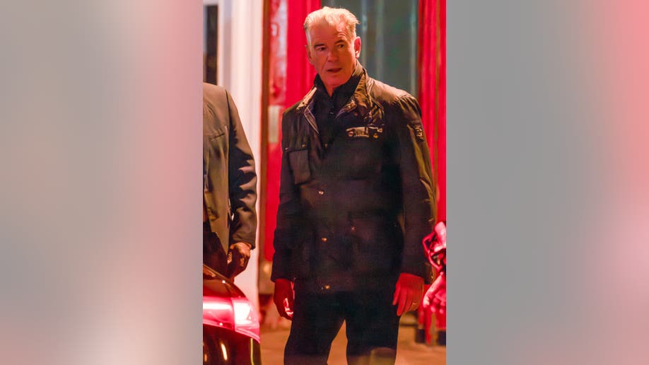 Pierce Brosnan stands outside Dorian restaurant in London after a family dinner, wearing a black jacket.