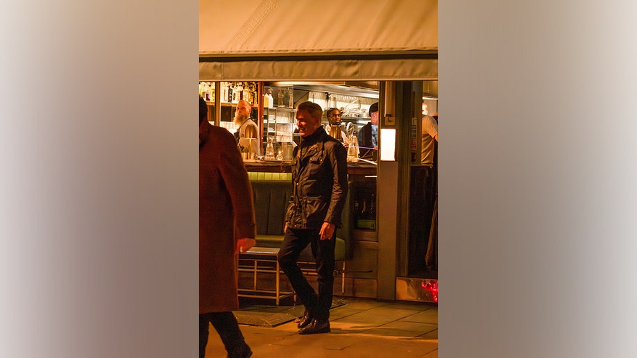 Pierce Brosnan leaving dinner with family photographed from the side.