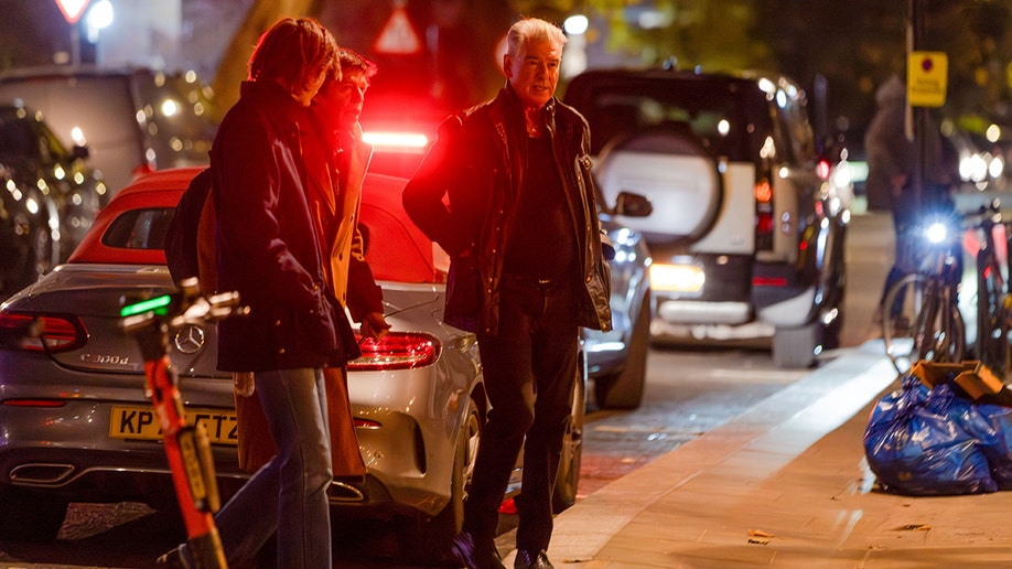 Brosnan family outside of a car on the street.