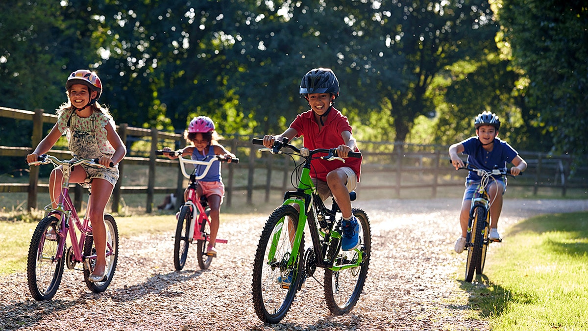 Four Children On Cycle Ride In Countryside Together