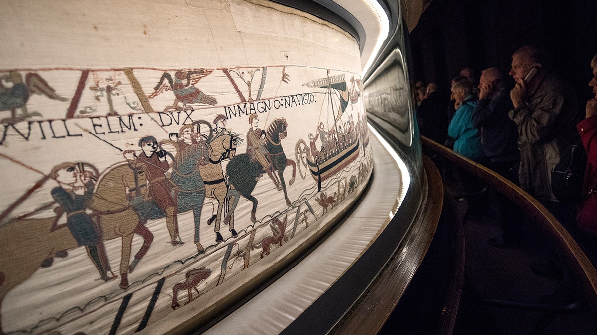 Museum goers admiring Bayeux Tapestry