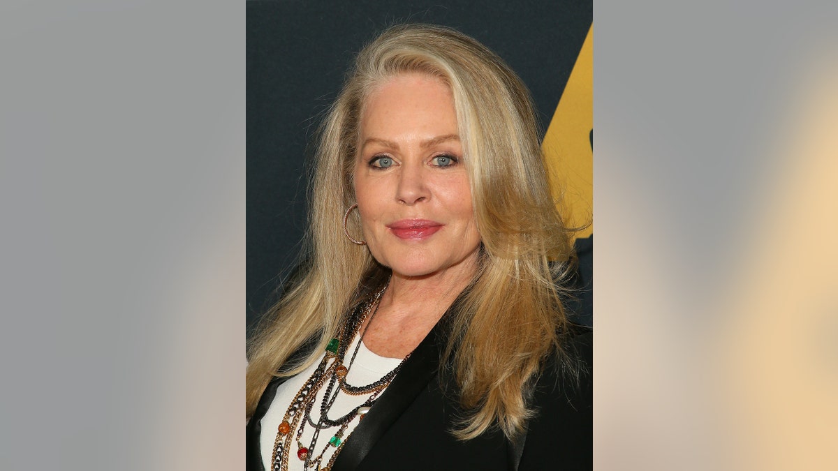 A close-up of Beverly D'Angelo smirking.