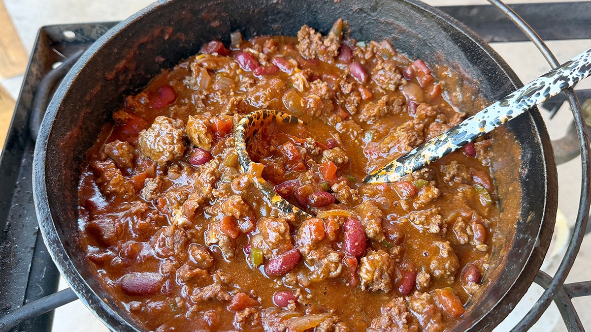 Bison chili cooks in a cast-iron pot.