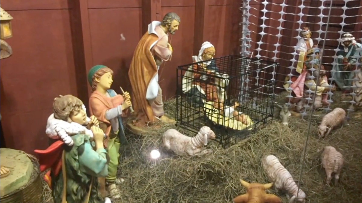 Nativity scene featuring Jesus in a cage