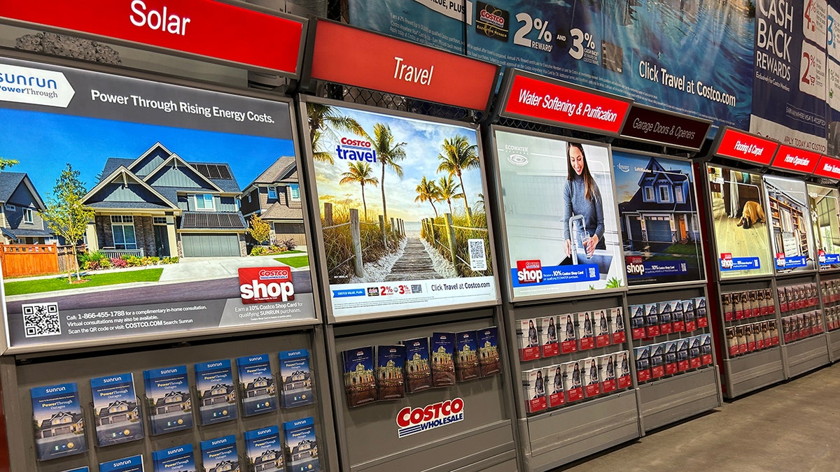 Costco Wholesale in-store service displays featuring solar, travel, water softening, and home improvement promotions.