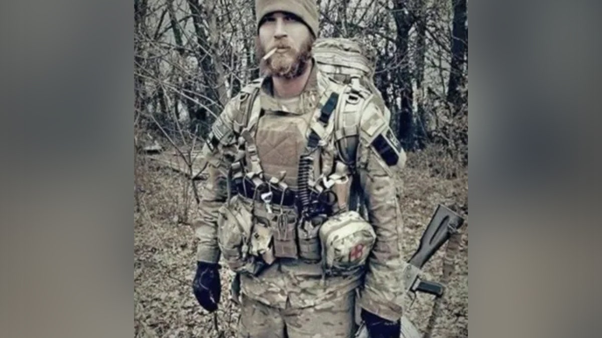 Solider dressed in camouflage with a cigarette in his mouth