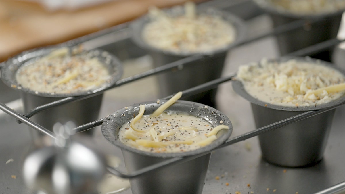 Popovers are seen in trays before being placed in an oven.