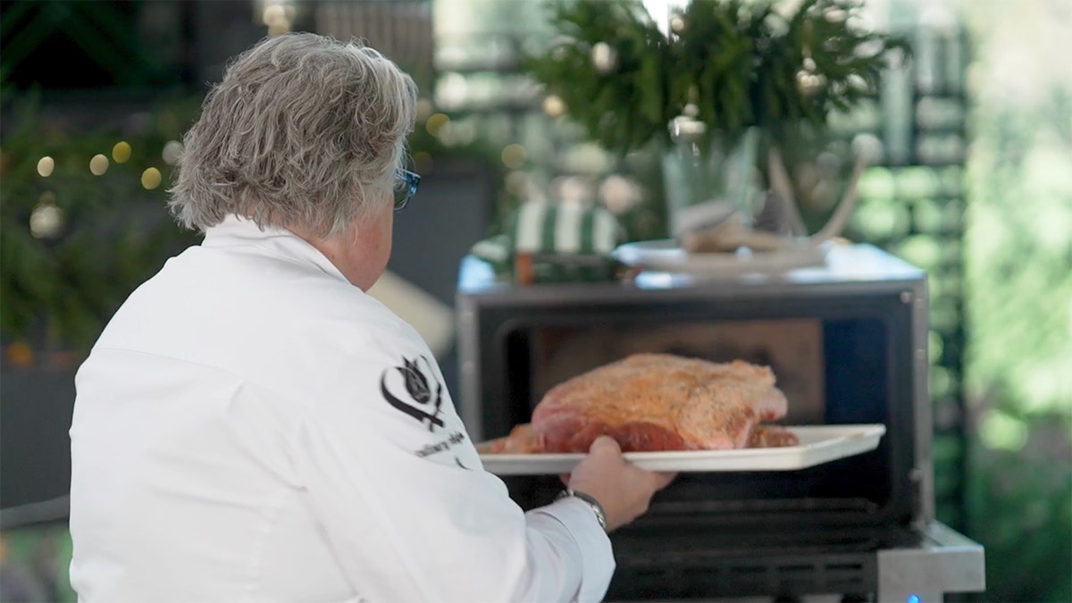 A chef puts a prime rib in the oven.