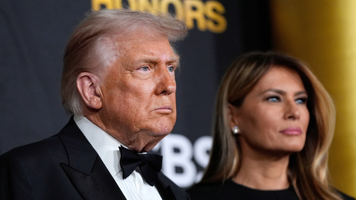 The U.S. president and first lady walk a red carpet at a formal cultural event in Washington.