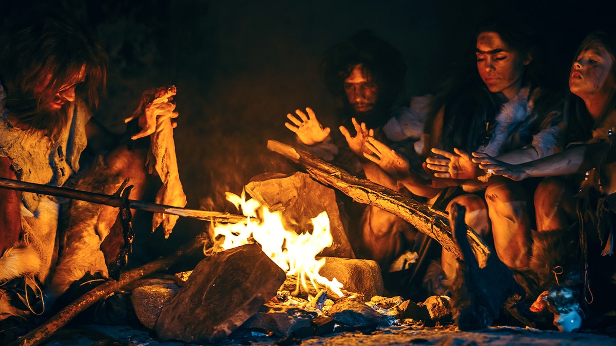 穴居人圍著火堆。