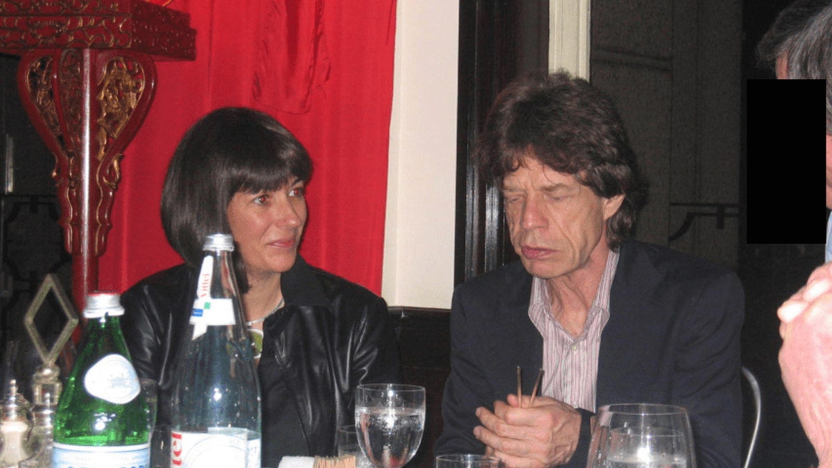 Ghislaine Maxwell and Mick Jagger appearing to be in conversation at a restaurant or lounge.