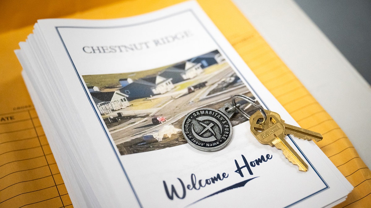 Close up of welcome packet and home keys from Samaritan's Purse
