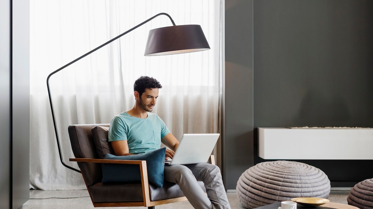 man sitting under floor lamp