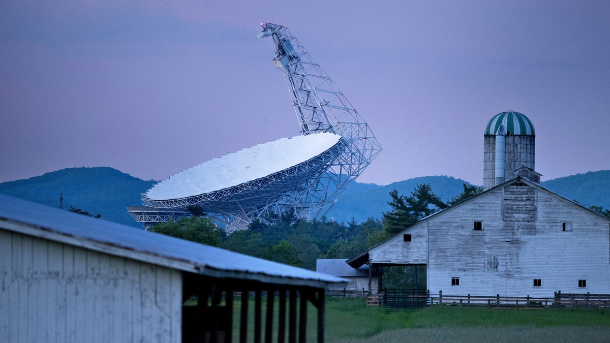Sunset shot of The Green Bank Telescope, a 100-meter fully steerable radio telescope, is seen near a farm in the Green Bank Observatory in the US National Radio Quiet Zone