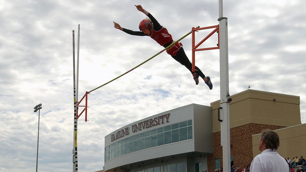 Pole vaulter jumping over bar at Hamline University