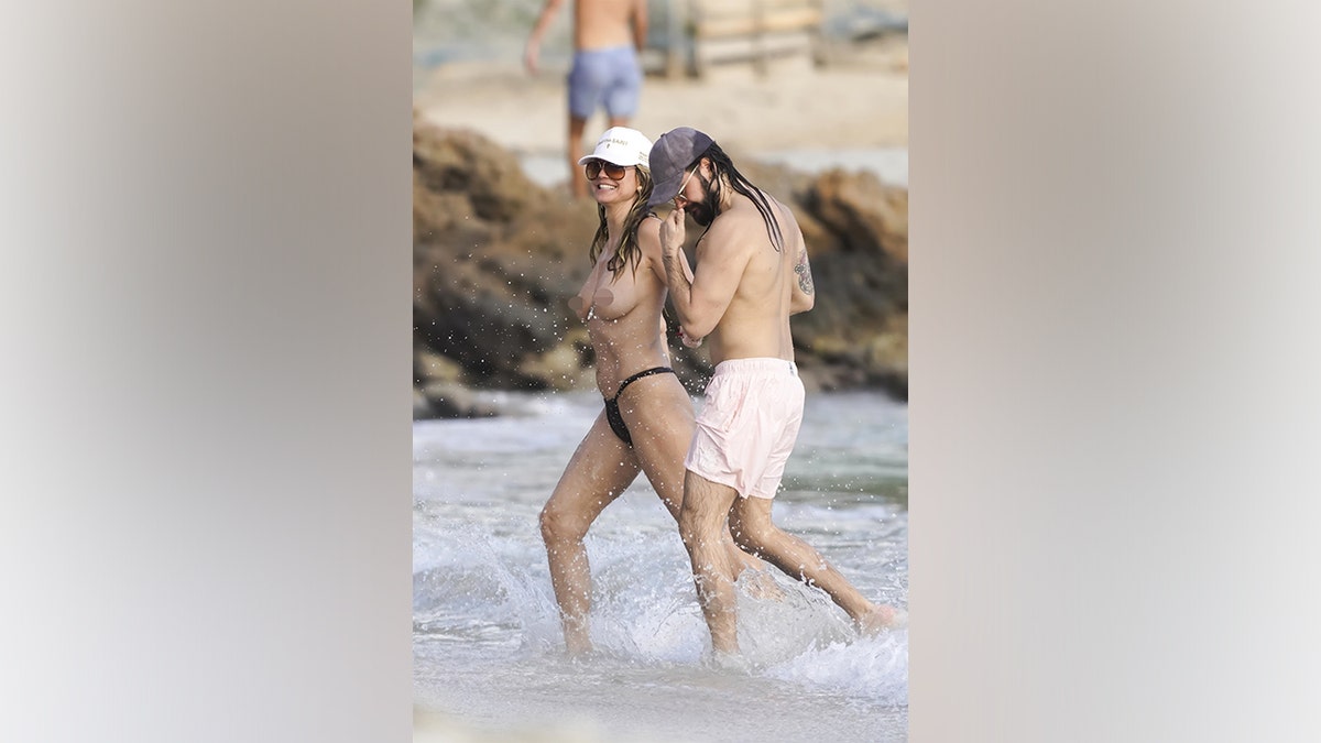 Heidi Klum and husband Tom Kaulitz walk along the shoreline during a beach day in St. Barts.