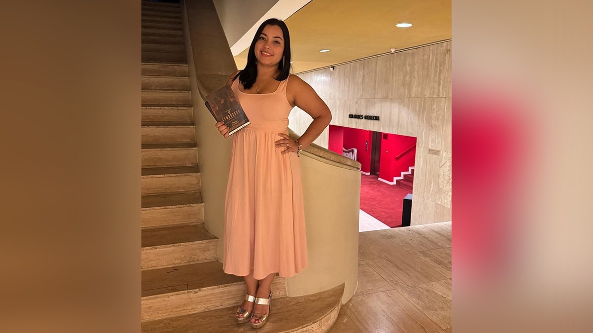 Helen Massiell Garay Sanchez in pink dress smiling on stairs